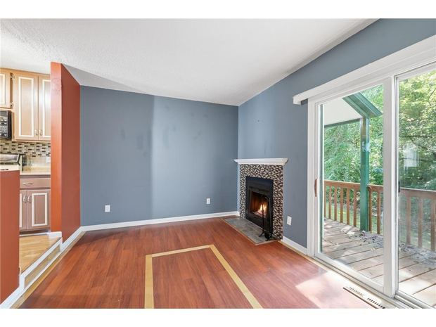 Living room with the fireplace and sliding door to the deck