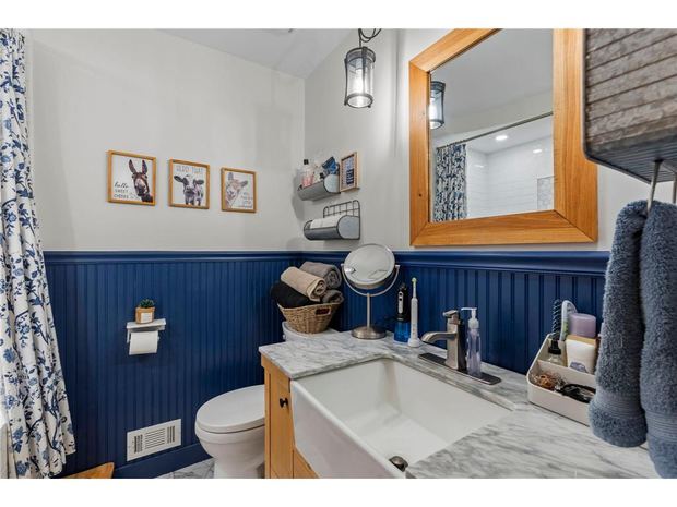 Bathroom with navy wainscot and a farmhouse sink