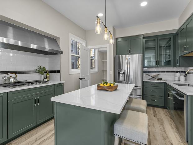 Kitchen with island, quartz counters, and double wall ovens