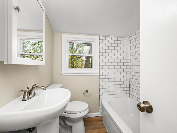 Upper suite bathroom with a tub and subway tile