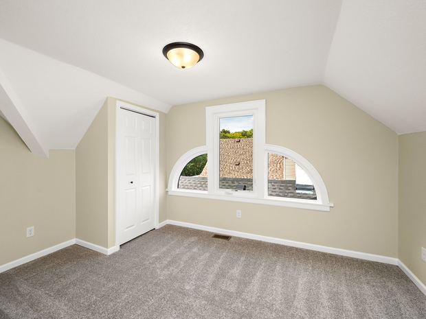 Third floor bedroom with an arched window
