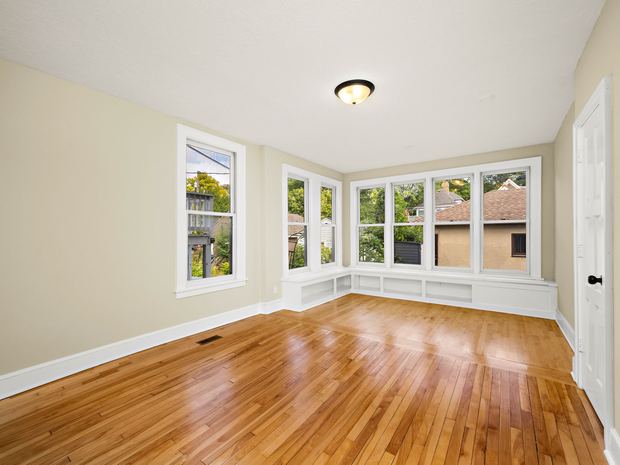 Lower unit room with corner windows and built in cabinets
