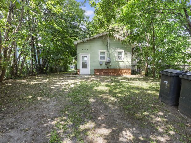 The home and the fenced yard with mature trees