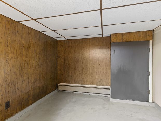 A room with wood panelling and baseboard heat