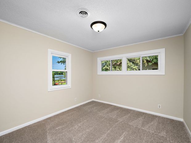 A bedroom with windows on two walls